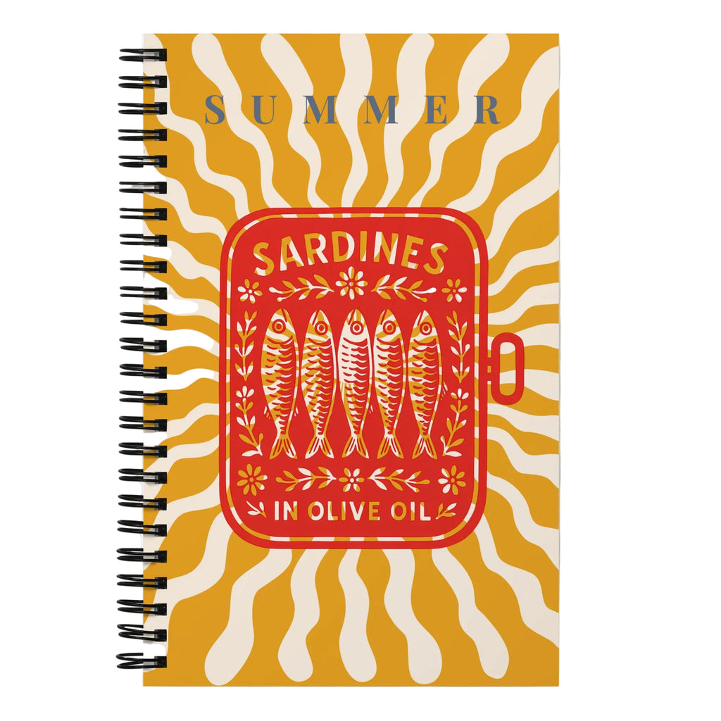 Un design unique : Carnet de notes sur le thème des sardines dans l'huile d'olive pour l'été. 
Couverture jaune et rouge avec illustrations de sardines stylisées. 
Ouvert sur une table en bois avec tapas : sardines grillées, pain, ail, citron, sel, herbes. 
Style rétro et unique.