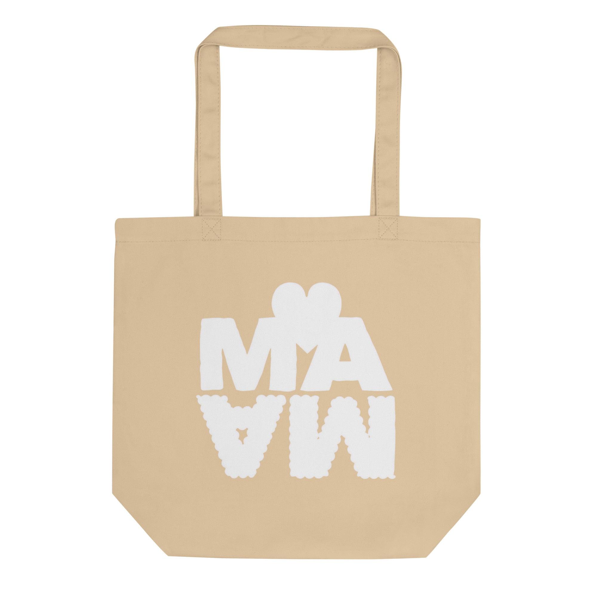 Sac cabas écologique de couleur beige sable avec l'inscription "MAMA" en lettres blanches épaisses. Le mot est stylisé avec un effet miroir vers le bas et surmonté d'un cœur blanc minimaliste. 
Design moderne et original sur fond blanc.