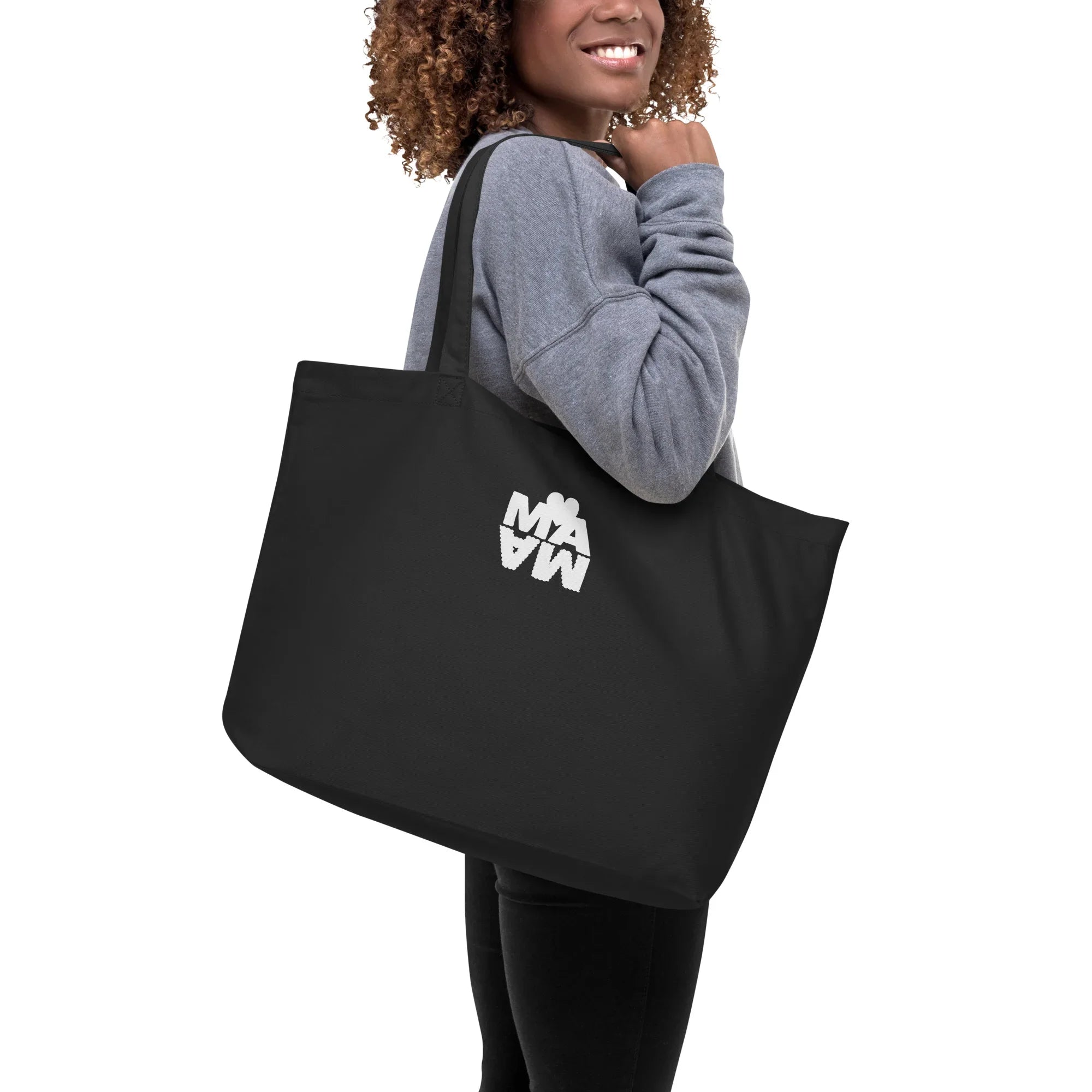 Femme portant un grand tote bag noir éco-responsable avec motif graphique blanc, style moderne