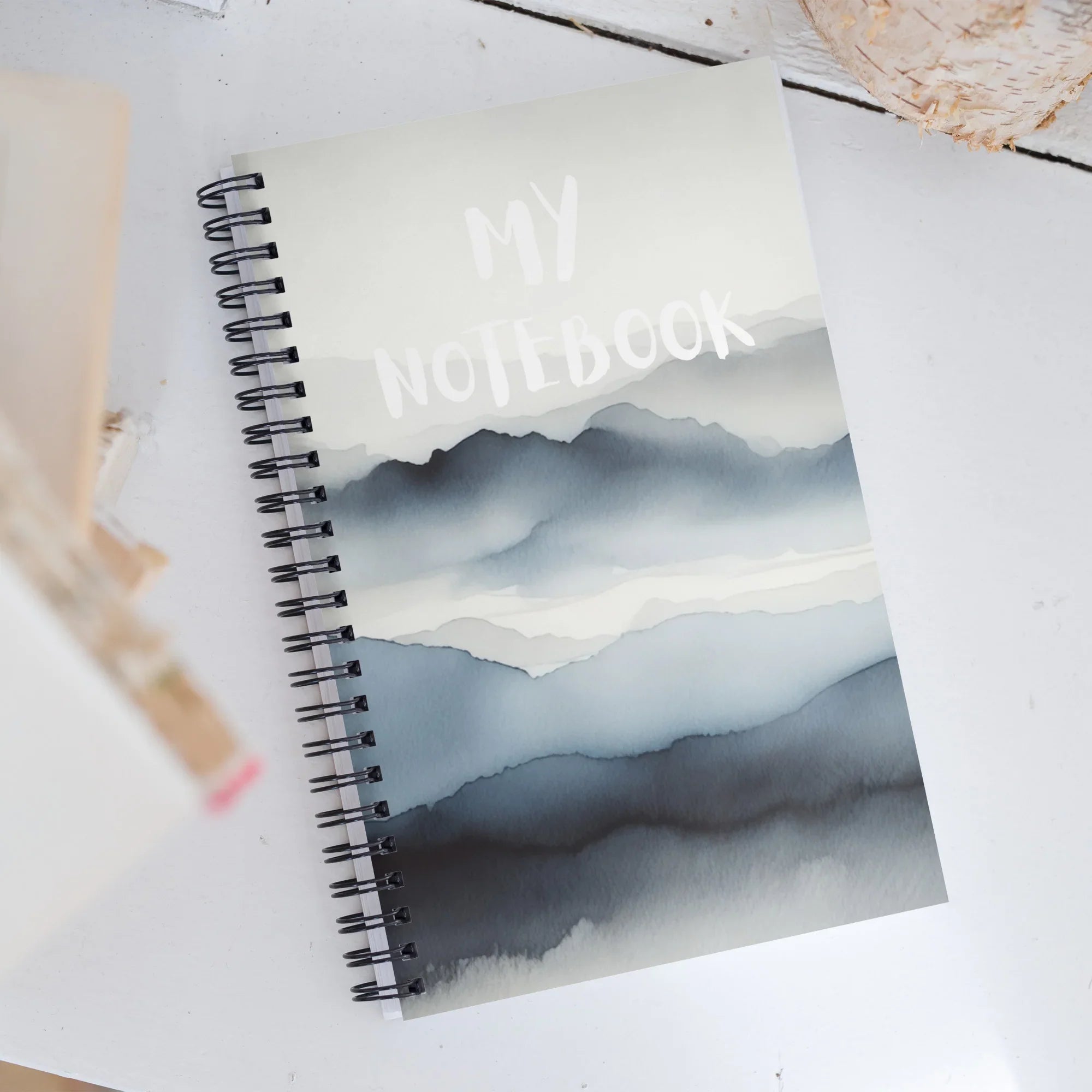Carnet à spirale couverture montagne aquarelle, inscription My Notebook, sur table blanche