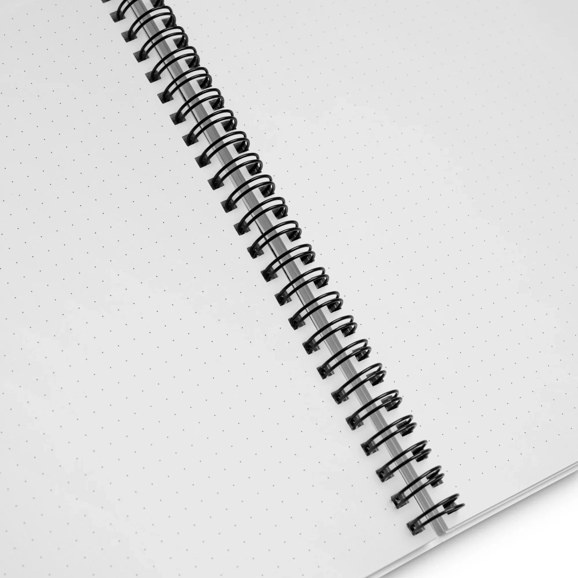 Carnet à spirale ouvert avec pages à points, vue détaillée des feuilles blanches.